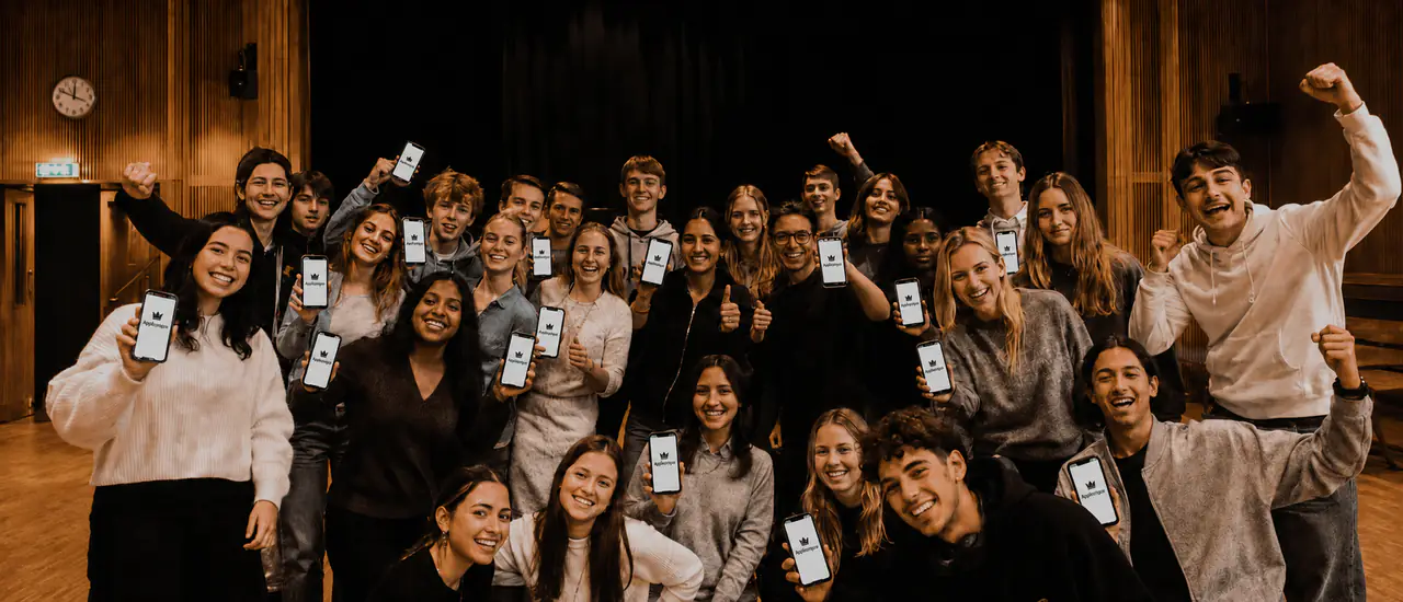 A happy group of young people show AppKungen on their phones during a shared fundraiser.